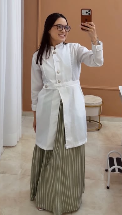 Carla Vieira usando jaleco em seu espaço de atendimento